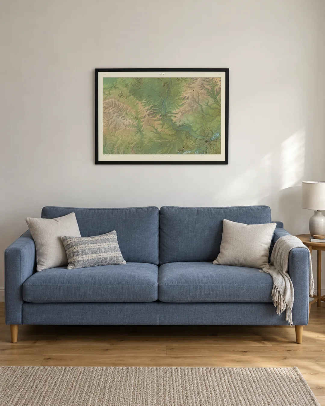 A Field and Fell map of Streatley, A1 in a black frame, hanging above a blue sofa in an illustrated living room